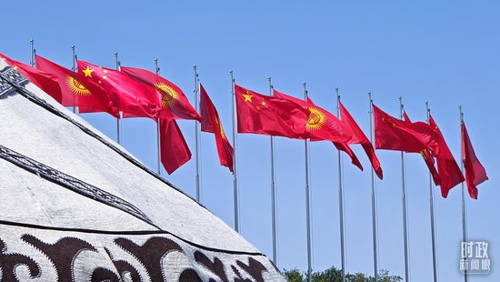 △玛纳斯国际机场上空飘扬的中吉两国国旗。（总台央视记者郭鸿拍摄）