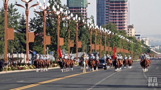  △在骑兵马队护卫下，习近平主席乘车前往和谐宫广场。（总台央视记者韩锐拍摄）