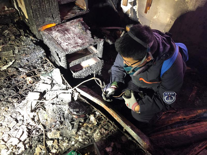 罗安在现场查看取暖器线路问题。殷梦昊 摄