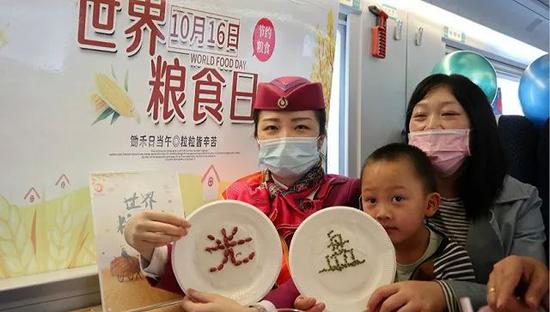  2020年10月15日，在重庆北开往万州北的C6404次列车上，乘务员向乘客宣讲拒绝餐饮浪费等知识。图片来源：人民视觉