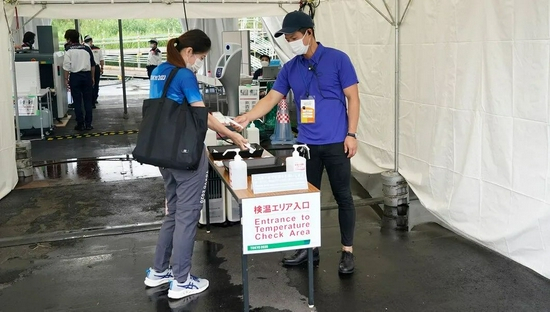  为了降低新冠疫情传播风险，进入奥运场馆前，志原者要进行体温测量。图/Tokyo 2020