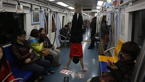 张尚武在地铁上卖艺。（图片来源：视觉中国）