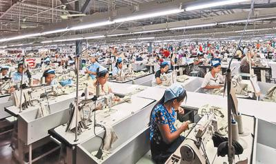  东隆（缅甸）服装有限公司厂房内，工人们正在加紧生产。 本报记者 李秉新摄