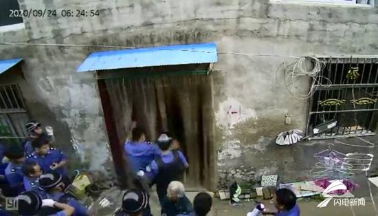 执法人员用脚踢开村民家大门。