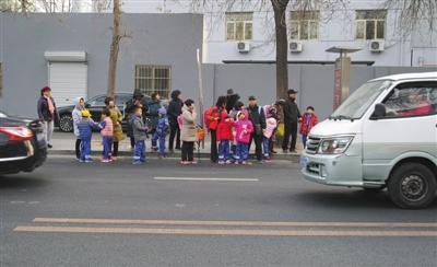 12月3日，北京，大风天气，放学后家长在寒风中接孩子们放学。 图/视觉中国