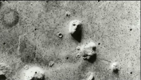 　　▲美国瓦伊金1号探测船传回的这张照片，让很多科学家大为震惊，那是外星人脸吗？ 图据纪录片《太空探秘：寻找外星人》