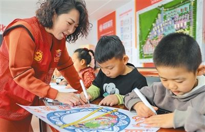 河北秦皇岛海港区文化路街道红旗里社区志愿者带领小朋友绘制“光盘行动”美术作品。 　　曹建雄摄