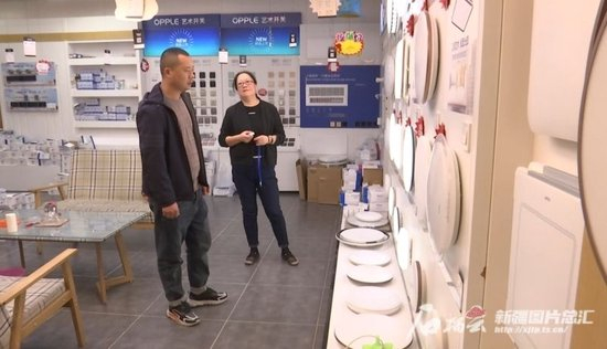  12月16日，在沙湾市一家家装商铺，消费者正在挑选灯具。段江玺摄