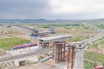 2018年6月13日，由中铁二十局承建的京张高铁崇礼支线最长桥赵川镇高架特大桥上跨唐呼铁路现浇连续梁转体成功。连续梁长144米，转体角度68度，单转体部分的总重量2306吨，转体73分钟后，在高空精准对接，这标志着京张高铁主线、崇礼支线最后一座连续梁转体成功。这是当日无人机拍摄的施工现场。新华社发（马佳琦 摄）