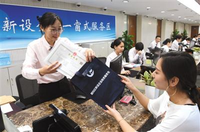 昨日，朝阳区政务服务管理局新设企业一窗式服务区工作人员向申请人发放营业执照、公章和“政务服务包”。新京报记者 吴宁 摄