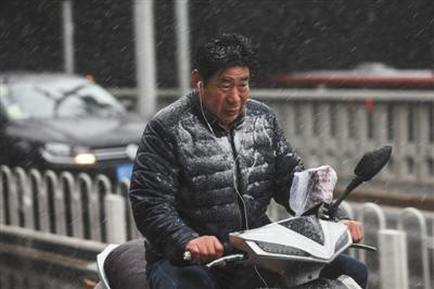 昨日，西三环，市民骑行在大雪中。新京报记者 浦峰 摄