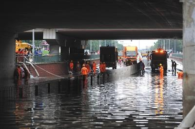 　　7月16日，昌平区回龙观育知东路轻轨桥下，抢险救援人员正在排水。A06-A07版摄影/新京报记者 王贵彬 彭子洋