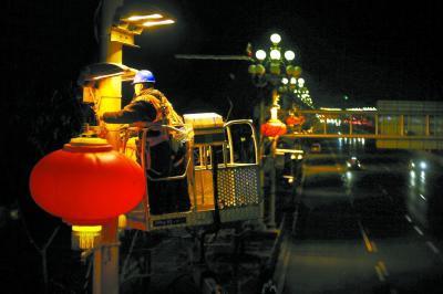 施工人员在长安街两侧的华灯灯杆上悬挂起一盏盏大红灯笼。本报记者&nbsp;方非摄