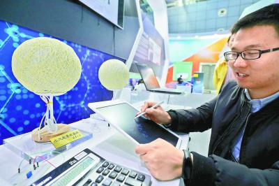 &nbsp;昨天，在中关村展示中心，清华大学的布展工作人员介绍水汽能量收集球的工作原理。本报记者&nbsp;饶强摄&nbsp;