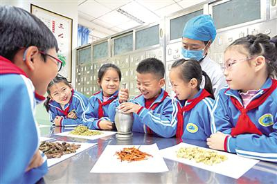 河北省内丘县平安小学学生在中药房体验研磨中草药。新华社发
