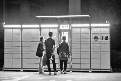 郑州某小区夜间在丰巢快递柜等待取货的居民