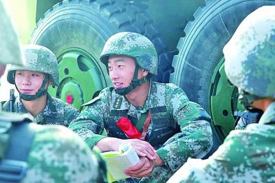  训练间隙，王金龙（中）与官兵一起交流学习体会。光明图片