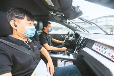 副驾驶座上的测试员手持设备记录监测自动驾驶车辆数据。新华社记者 王 翔摄
