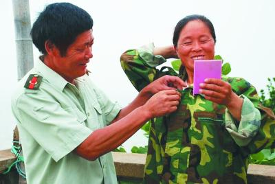 王继才给王仕花整理衣着。资料照片
