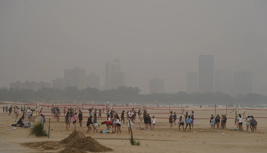 27日，芝加哥蒙特罗斯海滩边，建筑物被烟雾笼罩。图源：美联社