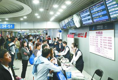 中转服务柜台，工作人员忙碌地为乘客办理中转、改签等服务。