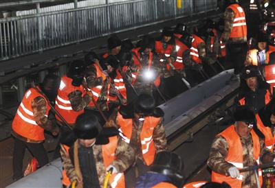 昨日凌晨，工人们一起用力撬起地上的道砟、扣件和轨枕。