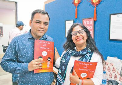 印华中文学校总裁伍莎（右）与学员展示她本人编写的汉语教材。记者 苑基荣 摄