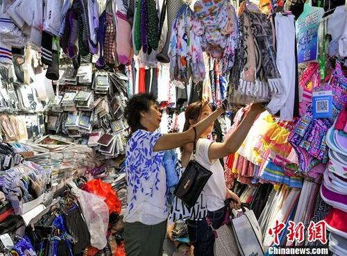 7月5日，新疆乌鲁木齐市一综合市场内，琳琅满目的商品吸引民众前来选购。中新社记者 刘新 摄