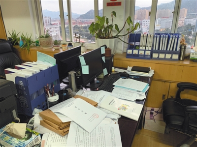 陈奔的办公桌上，摆满了正在处理的文件。 杨鹏 摄