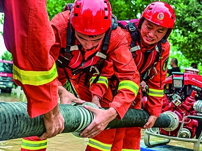 江苏南京消防救援队伍利用龙吸水和移动供水泵组对积水区域进行抽水排涝。应急管理部消防救援局供图
