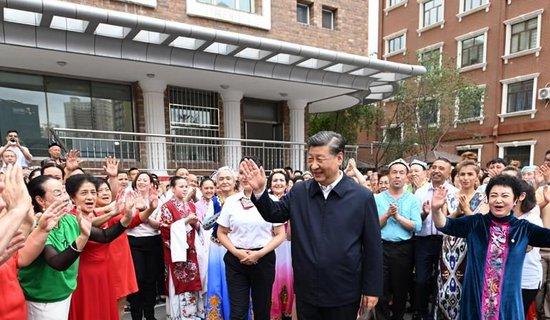 △2022年7月13日，习近平总书记在新疆乌鲁木齐市天山区固原巷社区考察时，向各族群众挥手致意。