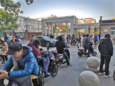 10月29日早上7时40分，展览路第一小学门前停满送孩子的车辆。 新京报记者 吴婷婷 摄