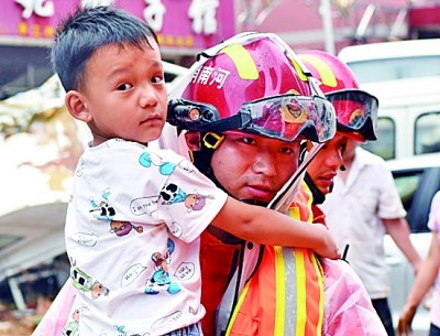 7月21日，在巩义市米河镇，消防救援人员帮助群众转移。新华社发