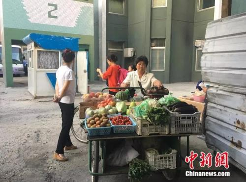 朝鲜人在街边卖蔬菜和水果。中新网记者 邱宇 摄