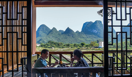 游客在广西桂林市阳朔县一家民宿喝茶聊天（2020年7月4日摄） 曹祎铭摄/本刊