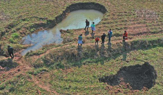 　▲中寨的两处地面塌陷坑。2017年统计的塌陷坑洞总共34个，近两年的塌陷情况尚在统计中。