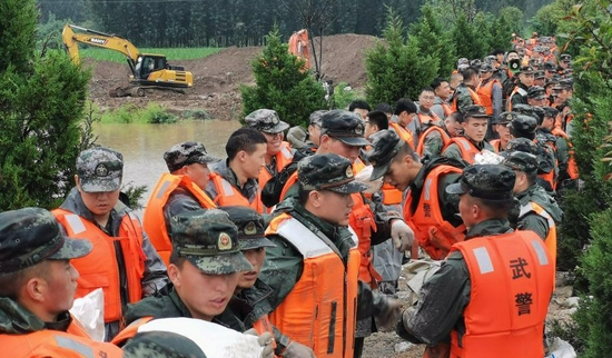 △2021年7月21日，武警河南总队新乡支队官兵在新乡市搬运沙袋封堵管涌。