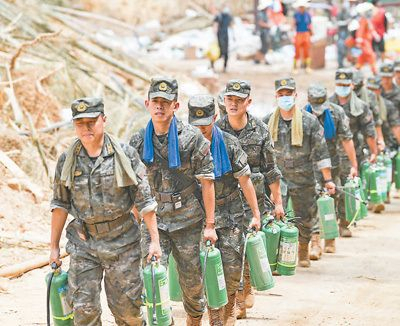 救援人员提着灭火器前行。　新华社记者 王全超摄