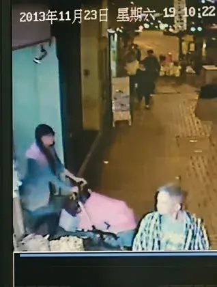 闭路电视拍下吴某推婴儿车出街时拉上挡风帘