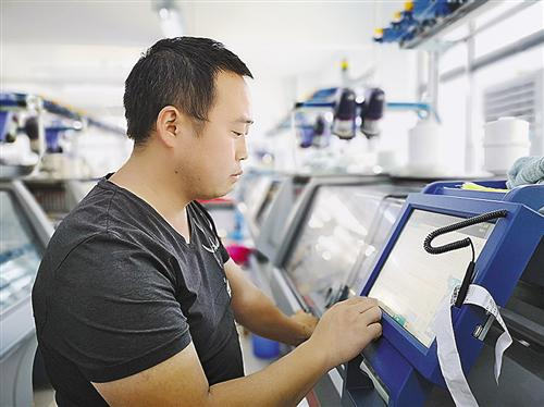 挡车工在智能织造车间操作一体成型无缝机。本报记者 李 哲 摄