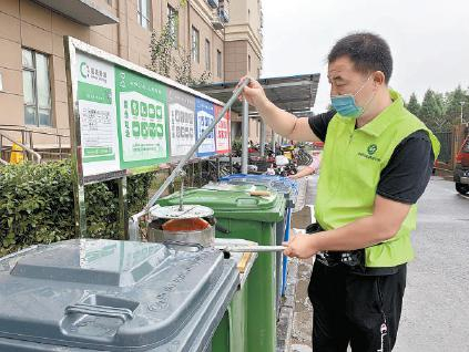 在百荣嘉园，垃圾分类指导员用“沥水神器”处理厨余垃圾。本报记者 白继开摄