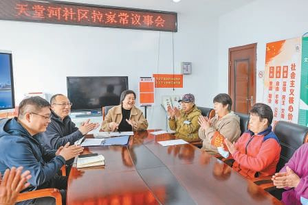  居民在宽敞的小区会议室里举行拉家常议事会。