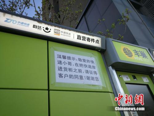 资料图：北京市某小区外的快递柜上张贴提示，提醒快递员放进货柜前首先征得收件人同意。中新网&nbsp;邱宇 摄