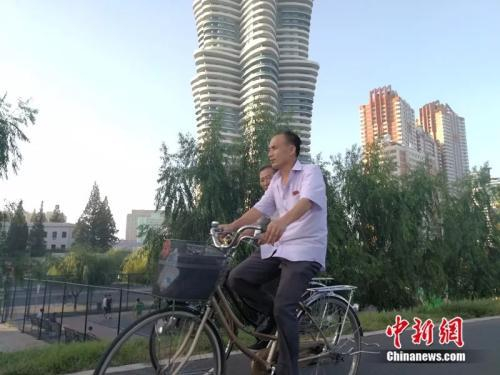 大同江边的公路上有人在骑车。中新网记者 邱宇 摄
