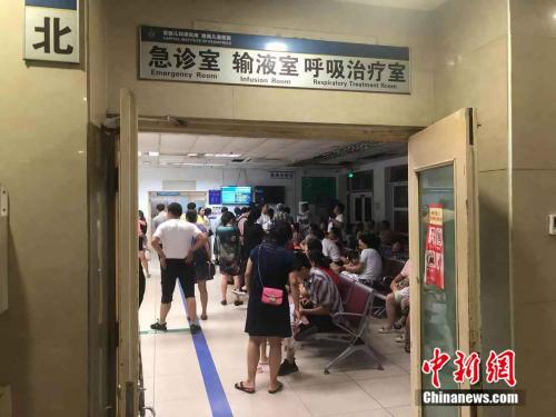 8月8日晚，儿研所急诊室内，不少患儿及家长正在候诊。冷昊阳 摄
