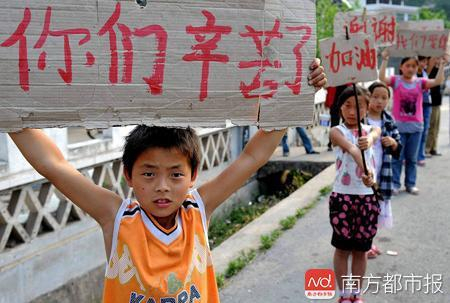 当年徐广手举自制纸牌“你们辛苦了”，感谢前来救援的官兵叔叔。