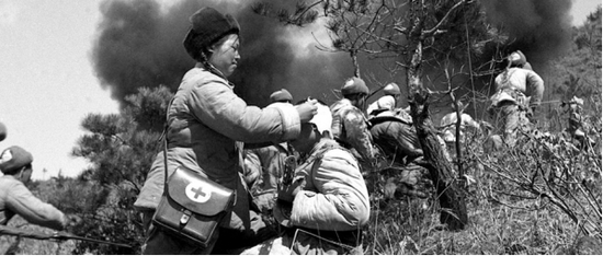  图为一名医护人员在炮火中救护伤员。