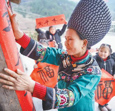 贵州铜仁市松桃苗族自治县黄板镇大寨村，村民正忙着贴春联。龙元彬摄（人民视觉）