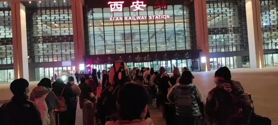 12月27日晚，希望回家的考生在火车站排队