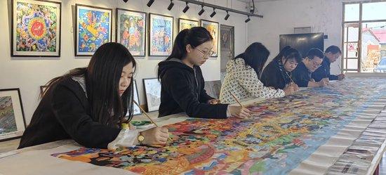 吉林省梨树县民间艺术家正在创作《关东七彩农民画、心系亚运向未来》农民画。受访者供图